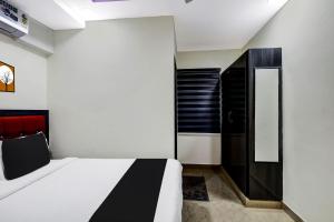 蒂鲁帕蒂OYO AADYA INN的一间卧室配有一张床和一个黑色橱柜