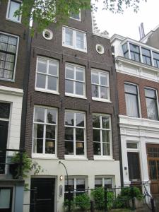 阿姆斯特丹海伦赫拉赫兹21住宿加早餐酒店的一座大型砖砌建筑,设有白色窗户