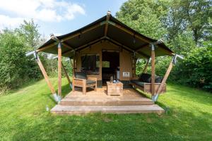 MeddooSafari tent 1 op Wellness Camping en B&B Stoltenborg的凉亭,带木甲板的田野