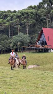 坎巴拉Chalés Corucacas的一群在田野里骑马的人