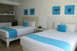 坎昆BSEA坎昆广场酒店的蓝色和白色的客房内的两张床