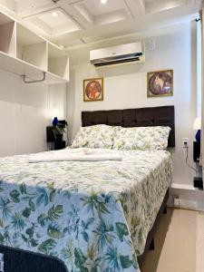 弗洛里亚诺波利斯Garden 437 Estúdios的一间卧室配有一张带花卉床罩的床