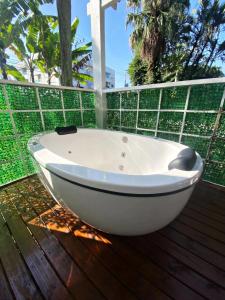 弗洛里亚诺波利斯Garden 437 Estúdios的木制甲板上的白色浴缸