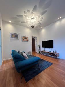 米兰Lattanzio Charming Suite - Porta Romana MM3的客厅配有蓝色的沙发和平面电视。