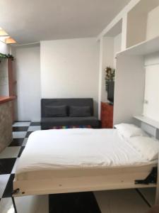 萨拉热窝Apartmani Zaara的一间卧室配有一张床和一张黑色沙发