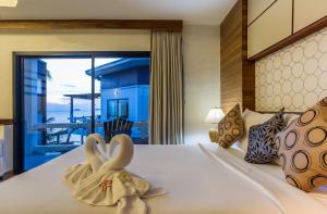 哈林海滩尼普顿别墅酒店的一间卧室配有一张带2条天鹅绒毛巾的床