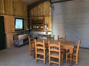 珀斯The Bothy and Wagon at Pitmeadow Farm的厨房配有木桌、椅子和水槽