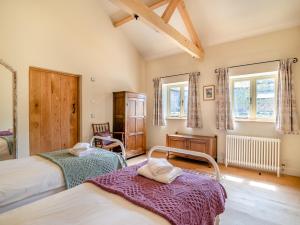 Stoke Abbott2 Bed in Beaminster 94406的一间卧室设有两张床和两个窗户。