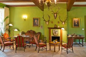 Ludorf卢多夫罗曼蒂克酒店的客厅设有绿色的墙壁、椅子和壁炉
