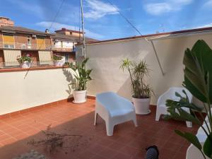 卡塔尼亚Lavica Di Mezzo Apartments的一个带植物和白色椅子的小阳台