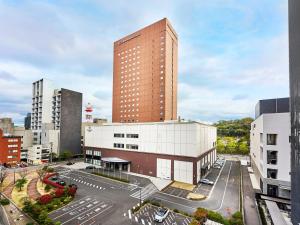 和歌山歌山大和鲁内酒店 的一座高楼,在城市里,有停车位