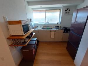 InokuchiGuesthouse tonari的厨房配有微波炉和冰箱。
