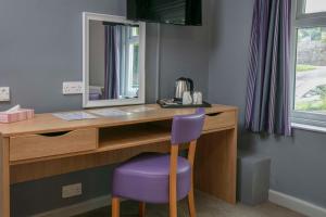 托基Tor Park Hotel, Sure Hotel Collection by Best Western的一张带镜子的桌子和一张紫色椅子