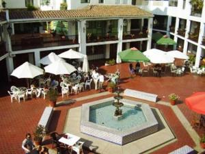圣地亚哥Hermoso Depto en sector alto de Las Condes的庭院设有喷泉、桌子和遮阳伞