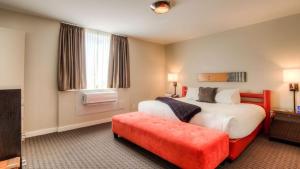 惠斯勒阿达拉酒店的酒店客房设有一张大床和一张红色长凳