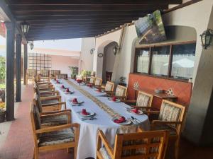 乔卢拉乔卢拉考古别墅酒店的长长的用餐室配有长桌子和椅子