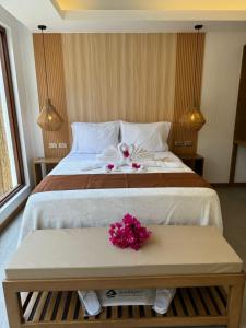 卢纳将军城赛尔高岛维拉斯酒店的一间卧室配有一张带鲜花的桌子的大床