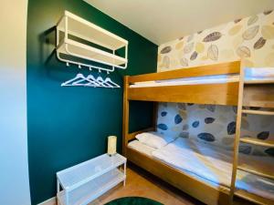 索尔布罗特Picture perfect Holiday Home in Sourbrodt with Garden BBQ的一间卧室设有两张双层床和绿色的墙壁