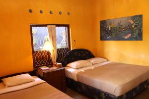 姆杜克古鲁拉特纳民宿的酒店客房设有两张床和窗户。