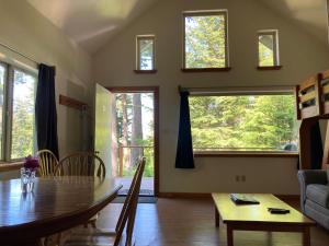 海恩斯罗德之家海滩山林小屋的客厅配有桌椅和窗户。