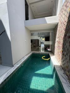 纳塔尔Casa de alto padrão的一座建筑物内带有黄色软管的游泳池