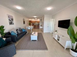 布里斯班South Brisbane 2-Bed with Views & Parking的客厅配有沙发和桌子