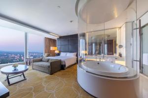 南京南京绿地洲际酒店的带浴缸和床的酒店客房