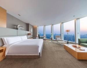 南京南京绿地洲际酒店的酒店客房带大型白色床和窗户。