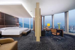 南京南京绿地洲际酒店的酒店客房,配有一张床、一张桌子和椅子