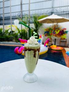 金边Pride Resort Cambodia的一杯饮料,一杯奶油,放在桌子上