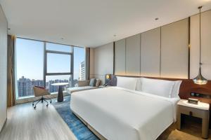 西安西安广成皇冠假日酒店的一张大白色的床,位于一个设有大窗户的房间