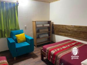 乌鲁班巴MAMA GREEN Veggie Hostal & Permaculture Farm的一间设有床铺和蓝色椅子的房间
