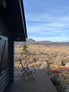 BlaskogabyggoCosy cabin with amazing view on the Geysir的坐在房子门廊上的一对椅子