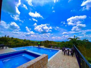 金巴亚Hotel Campestre Atardecer Cafetero的云天蓝色的游泳池