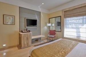 孟买福特住宅酒店的酒店客房,配有床和电视