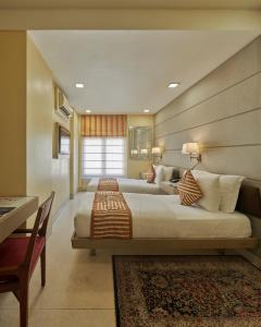 孟买福特住宅酒店的一间大卧室,配有两张床和一张桌子