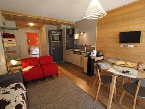 米茹Les Berlicants的一间带红色沙发的客厅和一间厨房