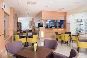 布拉迪斯拉发布拉迪斯拉发酒店 的用餐室配有桌子和黄色椅子