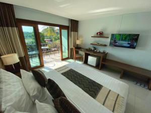 清盛暹罗三角酒店的一间卧室配有一张床、一台电视和一个阳台