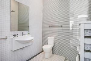 拜伦湾Exquisite 5-Bedroom Coastal Haven in Byron Bay的白色的浴室设有卫生间和水槽。
