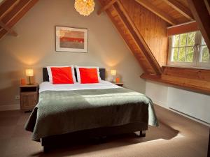 哈克斯卑尔根Natuurlogies Buurse Buiten的一间卧室配有一张带红色枕头的大床