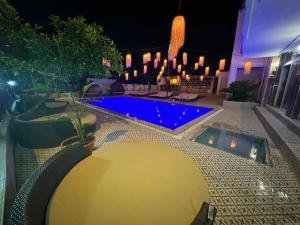 安塔利亚GÜLER BUTİK HOTEL的夜间在院子里的游泳池