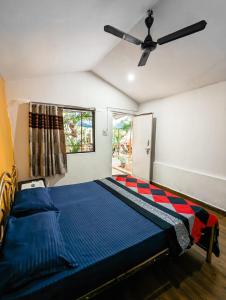 阿姆波尔Nature of Arambol的一间卧室配有一张床和吊扇