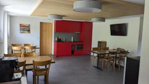 阿德尔博登BnB Fellacher的厨房配有红色橱柜和桌椅