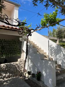 伊万多拉克Apartmani "Nikola" Seaview - Ivan Dolac, Hvar的通往白色房子的楼梯,有楼梯和植物