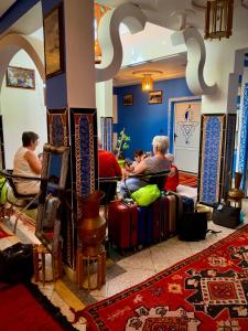 布马伦Hôtel Riad Atlas Dades的一群人坐在一个房间里,带行李