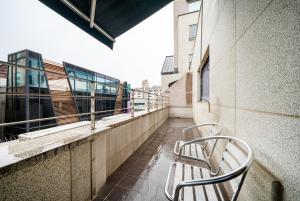 城南市Bundang Regency Hotel的两把椅子坐在大楼的阳台上