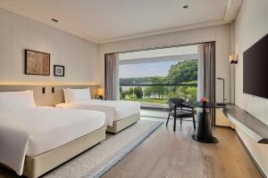 广州广州鸣泉居酒店的酒店客房设有两张床和窗户。