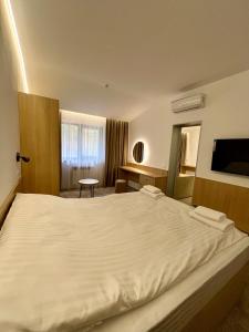 Tsarivka卡里维卡酒店的卧室配有一张白色的大床和一张桌子