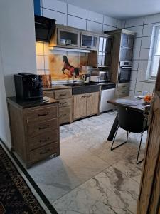 LauchhammerAntike Wohnmöglichkeit kurz und Langfristig 100qm 1 Stock的厨房配有木制橱柜和桌子